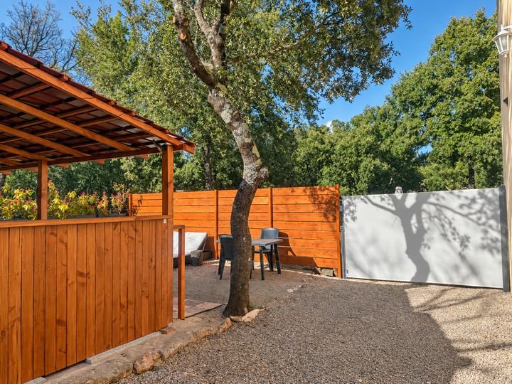 La terrasse couverte sous les chênes